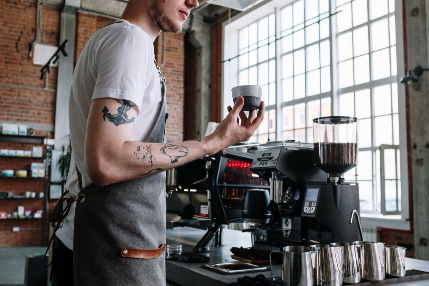 A barista at the machine, cup in hand